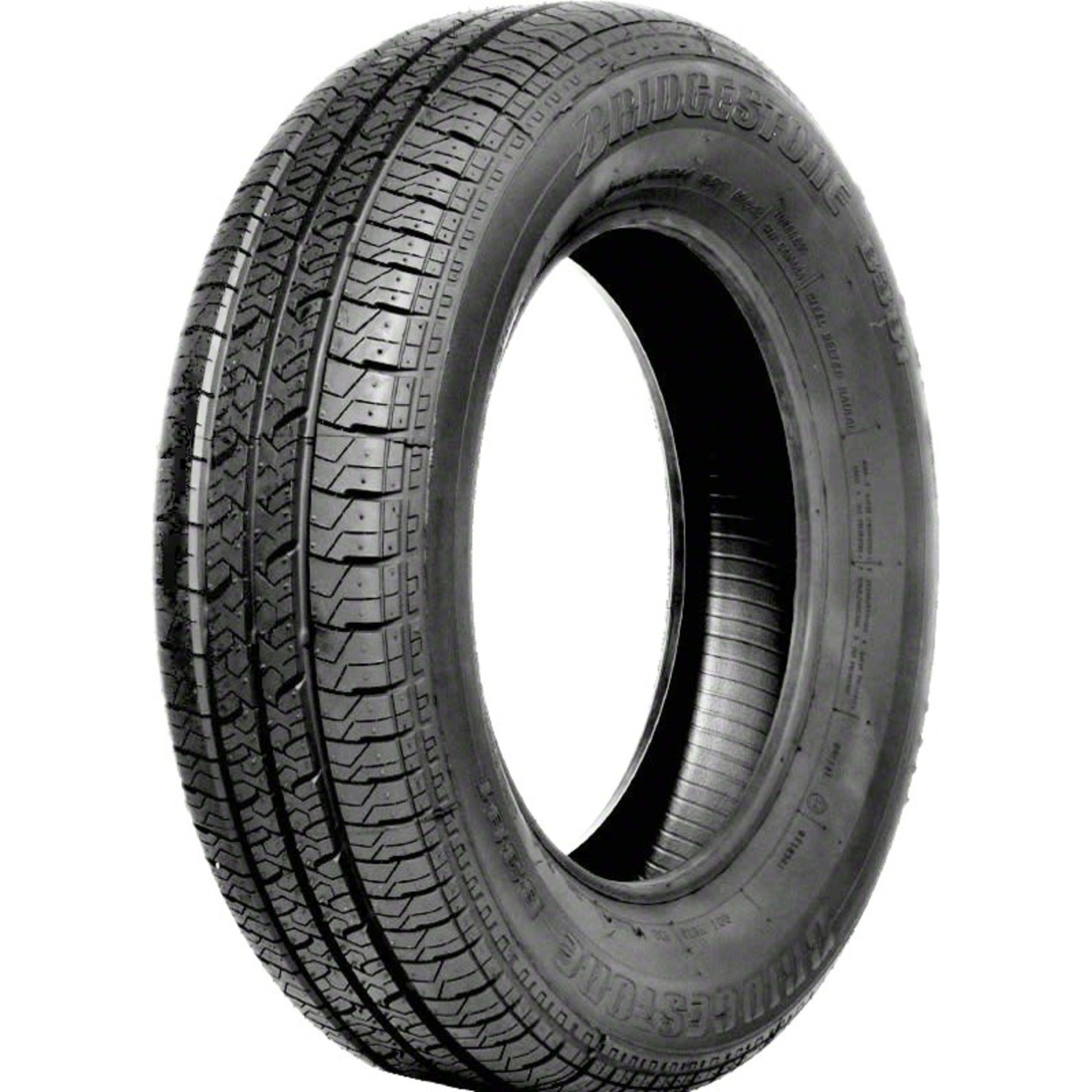 Vue rapprochée en biais d’un pneumatique montrant l’ensemble de la bande de roulement, ses rainures longitudinales et ses pavés sculptés.